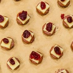 small pastries with cranberry toppings are on a baking sheet, ready to be baked