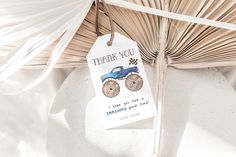 a thank you tag hanging from the side of a palm tree with a blue truck on it