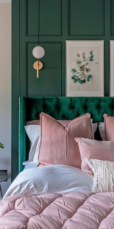 a green headboard with pink and white bedding in front of two pictures on the wall