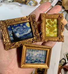 three paintings are being held up in the palm of someone's hand with them