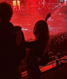 two people standing in front of a crowd at a concert