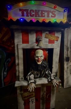 a creepy clown is sitting in a booth