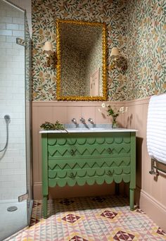 a bathroom with a sink, mirror and green cabinet in the middle of the room