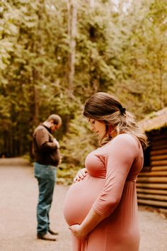 a pregnant woman standing next to a man