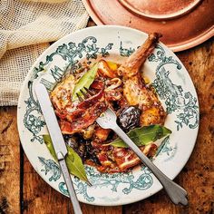 a plate with some meat on it next to a pot and spoon, sitting on top of a wooden table