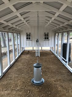 the inside of a building with windows and a ladder hanging from it's ceiling