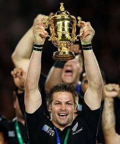 the rugby player is holding up his trophy