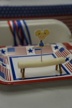 a cake shaped like a girl on a red, white and blue tray with american flag decorations