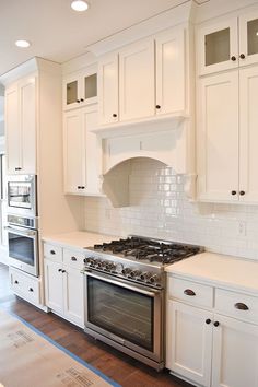 a kitchen with white cabinets and an oven