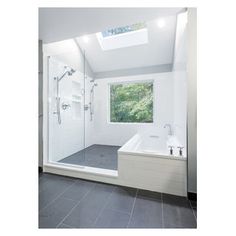 a white bathroom with a skylight above the bathtub and walk - in shower