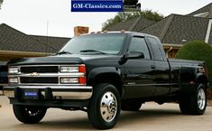 a black pickup truck parked in front of a house