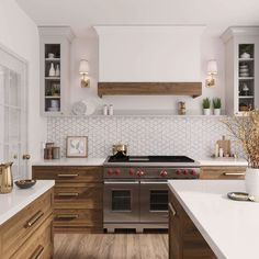 a kitchen with white counter tops and wooden cabinets, along with stainless steel oven hoods