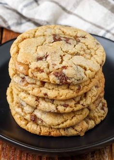 a stack of chocolate chip cookies on a black plate