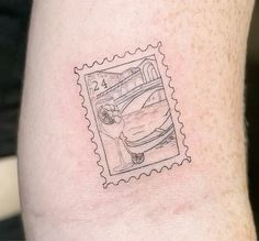 a postage stamp with a drawing of a plane on it's side, in the middle of a man's arm