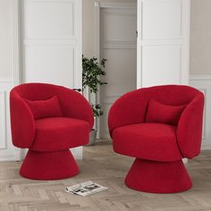 two red chairs sitting next to each other on top of a hard wood floored floor