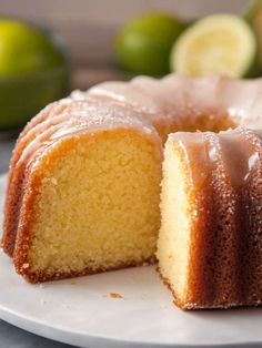 a bundt cake on a white plate with limes in the background