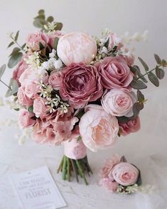 a bridal bouquet with pink flowers and greenery