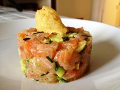 a white plate topped with food and a small cracker on top of the dish