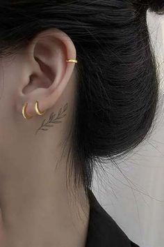 a woman's ear with two small leaves on the back of her left ear