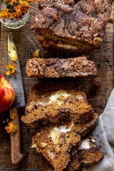 slices of apple bread on a cooling rack with an apple in the background and flowers