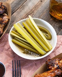 chicken wings, pickles and dipping sauce on a table