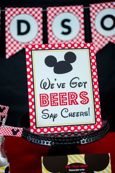 a mickey mouse themed birthday party with red and white polka dot banner, wine bottle wrappers, and napkins