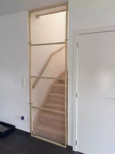 an open door leading to a set of stairs in a room with tile flooring