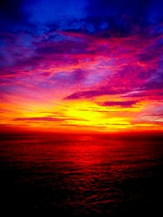 a colorful sunset over the ocean with clouds