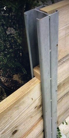 a piece of wood that has been placed on the side of a building with metal posts