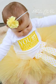 a baby girl wearing a yellow tutu skirt and t - shirt that says you are my sunshine onesie or shirt