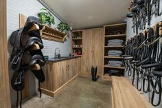 there are many pairs of shoes hanging on the wall in this room with wooden cabinets