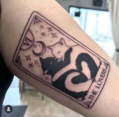 a black and white tattoo on the arm of a person with an image of two cats