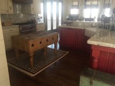 a kitchen with wooden floors and white cabinets