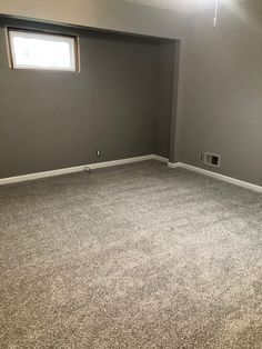 an empty living room with carpeted floors and gray walls