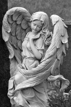 an angel statue with the words dear angels written in white on it, next to a grave