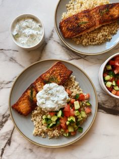 two plates with fish, rice and vegetables on them