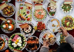 a table filled with lots of different types of plates and bowls full of food on it