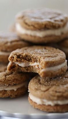 several cookies with white frosting are stacked on a plate