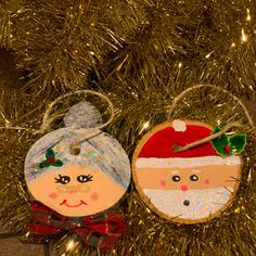 two ornaments are hanging from a christmas tree