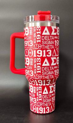 a red and white travel mug with the word delta printed on it's side