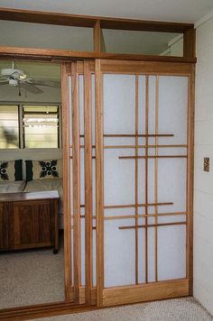 a room with a sliding glass door that has wood frame and frosted glass on it