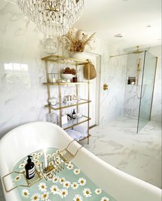 a bathroom with a claw foot bathtub and white marble walls, decorated with daisies