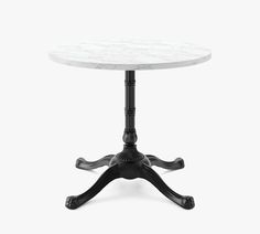 a white marble table with black legs and an ornate design on the top, against a white background