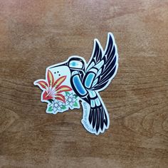 a sticker depicting a bird with flowers on it's body and wings flying in the air