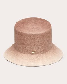 An elevated take on a traditionally casual style, the Ruby bucket hat pairs its classic flat-top crown with an asymmetrically shaped brim inspired by high-low hemlines. The wool felt topper is decorated with a subtle 14-karat gold plate that displays Eugenia Kim's signature logo. Flat crown Asymmetric brim 14k gold logo plate detail 100% wool felt Spot clean only Made in China Measurements Crown: 3.5in Front brim: 2in Back brim: 3.5in Casual Gold Hat, Luxury Cream Classic Felt Hat, Luxury Classic Cream Felt Hat, Luxury Classic Beige Felt Hat, Luxury Cream Felt Hat For Women, Luxury Cream Wool Hat, Eugenia Kim, Gold Logo, Flats Top