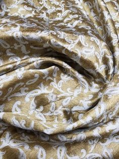 a close up view of a gold and white paisley print fabric