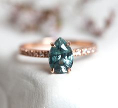 a ring with a large blue stone on the front and side, sitting on top of a white cloth