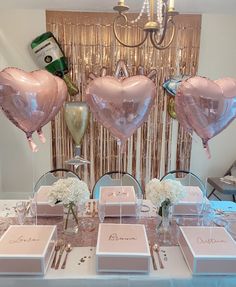 the table is set with pink heart shaped balloons