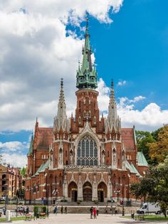 people are standing in front of a large building with many spires on it's sides