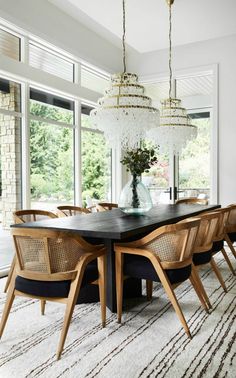 a dining room table surrounded by chairs and chandelier